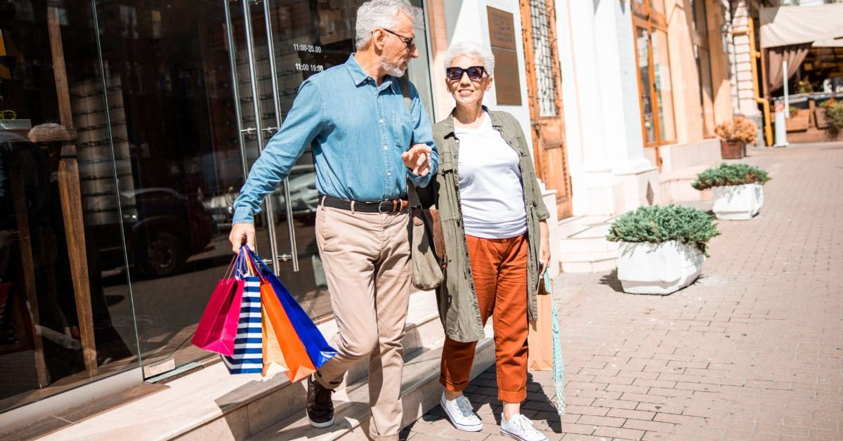 Older mature couple walking with retail shopping
