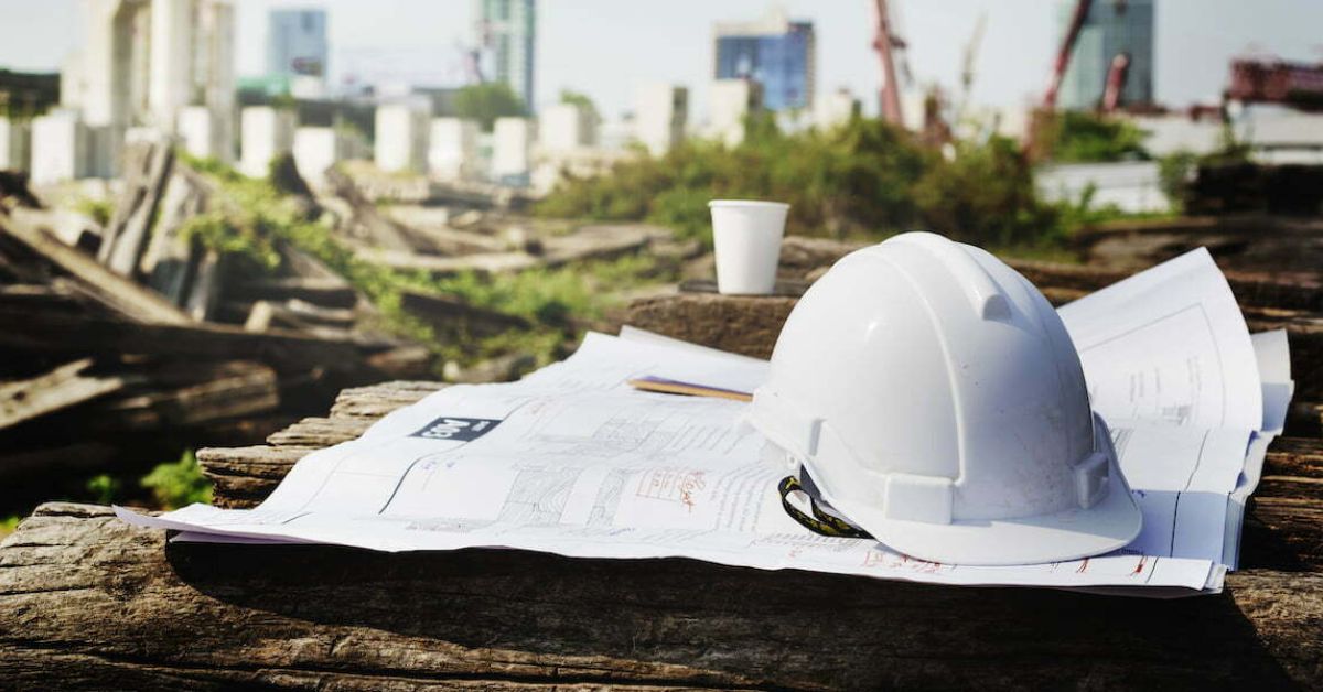 Building plans and a hard hat on a site