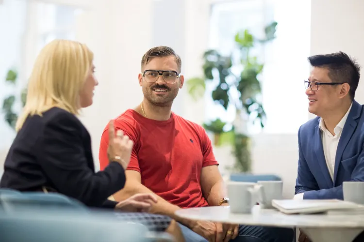 bright office with 3 people in discussion | Featured Image for the Buying Agent Services page.